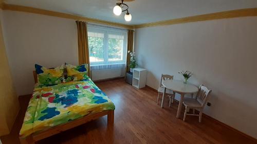 1 dormitorio con 1 cama y 1 mesa con sillas en Willa Saba Międzywodzie, en Międzywodzie