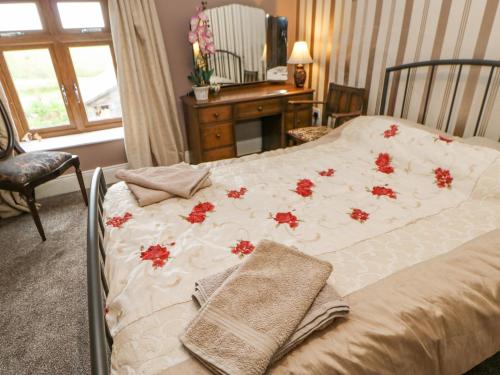 a bedroom with a bed with red flowers on it at 3 Tindale Terrace in Brampton