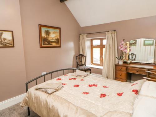 a bedroom with a bed with red flowers on it at 3 Tindale Terrace in Brampton