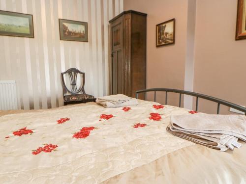 a bedroom with a bed with red flowers on it at 3 Tindale Terrace in Brampton