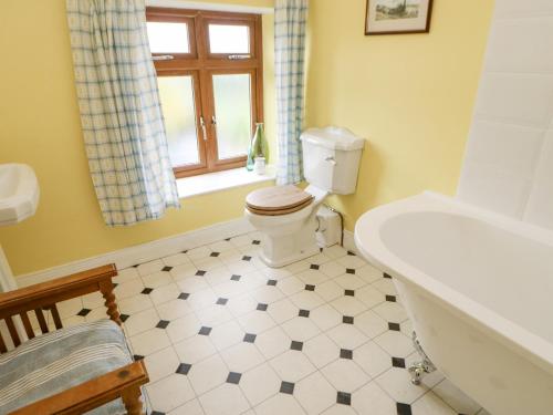 a bathroom with a toilet and a tub and a window at 3 Tindale Terrace in Brampton