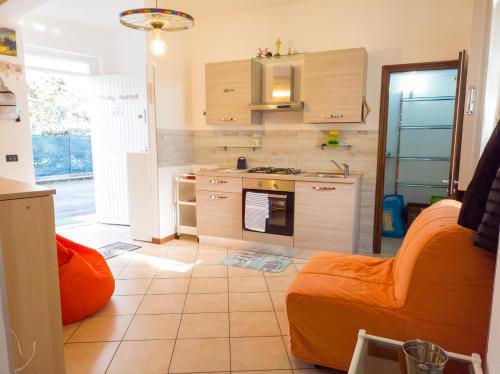 a kitchen with an orange couch and a stove top oven at BIKE HOUSE 4 "beach" in Seriate