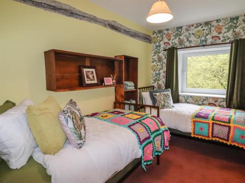 a bedroom with two beds and a window at The Other Place in Holmfirth