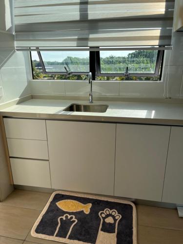 a kitchen with a sink and a kitchen rug at Mutiara Melaka Beach Resort by LaLuna in Melaka
