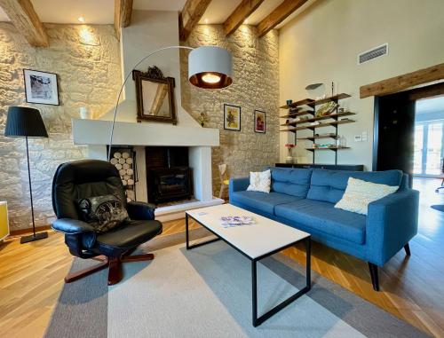 a living room with a blue couch and a fireplace at L'Atypique - grande terrasse, calme, centre ville in Avignon