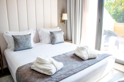 two beds with towels on them in a room with a window at MASA Hotel & Spa Campo Grande Collection in Lisbon