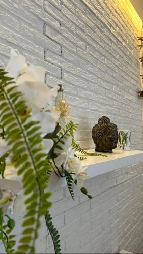 a white shelf with a statue and flowers on it at Hotel rural Finca Vivaldi Nature & Spa in San Miguel de las Dueñas