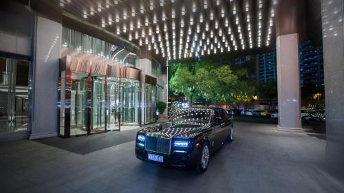 a black car parked in front of a building at Kingdom Hotel in Yiwu