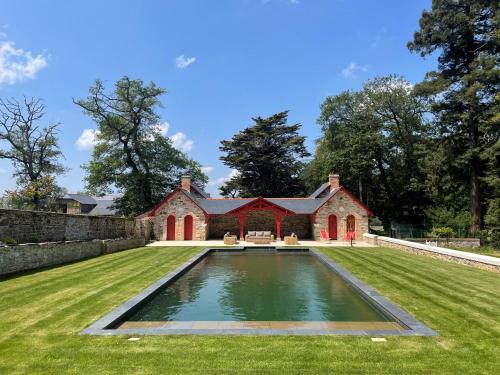 a house with a swimming pool in the middle of a yard at Chateau LE BROSSAY in Renac