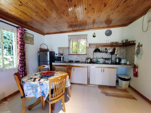 uma cozinha com uma mesa e uma pequena mesa e uma cozinha com em The Reef Palm em Anse aux Pins