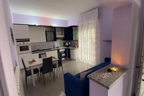 een woonkamer met een blauwe bank en een keuken bij Casa vacanze “Villa Paola” in Pescara