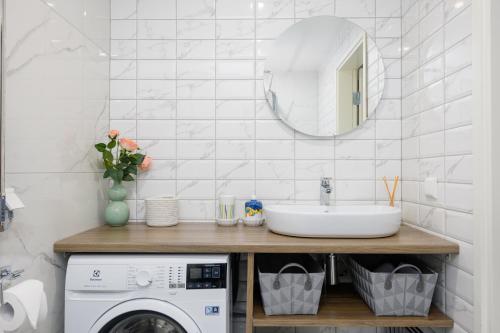 uma casa de banho com um lavatório e uma máquina de lavar roupa em Aiaviisa apartment em Pärnu