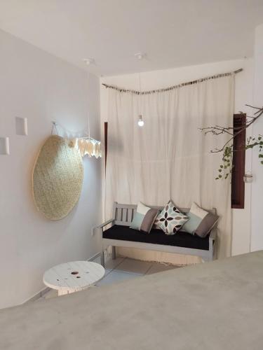 um quarto com um sofá e uma janela com almofadas em Flat ideal no centro de pipa! em Pipa