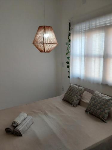 a bedroom with a large bed with a lamp and pillows at Flat ideal no centro de pipa! in Pipa