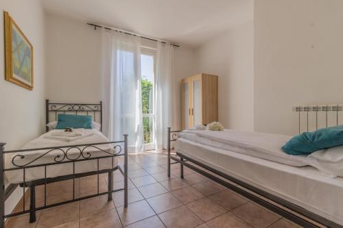 1 Schlafzimmer mit 2 Betten und einem großen Fenster in der Unterkunft Il Tramonto sul lago Varenna in Varenna