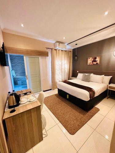 a bedroom with a large bed and a desk in it at LIVE-INN LUXURY SUITES in Mahalapye