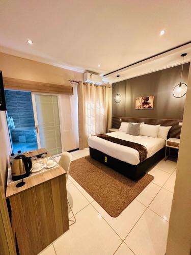 a bedroom with a large bed and a desk in it at LIVE-INN LUXURY SUITES in Mahalapye