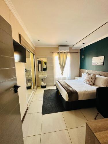 MahalapyeにあるLIVE-INN LUXURY SUITESのベッドとバスルーム付きのホテルルームです。