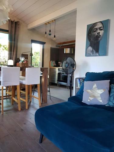 un salon avec un canapé bleu et une table dans l'établissement Loft atypique en bord de plage, à Capbreton