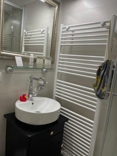 ein Badezimmer mit einem weißen Waschbecken und einem Spiegel in der Unterkunft Hotel Alte Posthalterei in Creuzburg