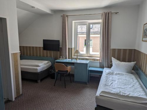 シュヴェットにあるParkhotel Schwedtのベッドとデスクが備わるホテルルームです。