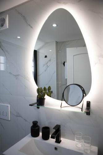 a bathroom with a mirror and a sink at Flowers & Faces Guesthouse in Ponte de Lima
