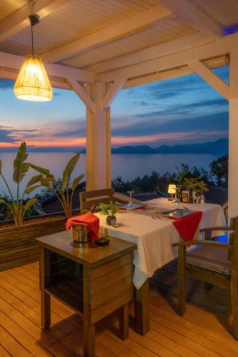 a dining room with a table and a view of the ocean at Vista Del Amor Faralya in Fethiye