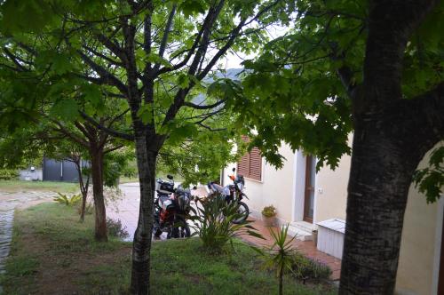 a motorcycle parked next to a building with trees at Casa vacanze da Anna in Tortolì