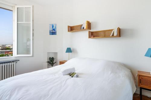 - une chambre avec un lit blanc et des étagères murales dans l'établissement Charming 1br at the doors of Paris - Welkeys, à Issy-les-Moulineaux