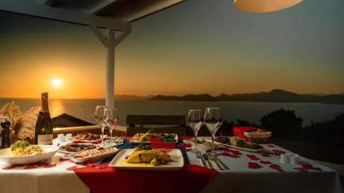 a table with plates of food and glasses of wine at Vista Del Amor Faralya in Fethiye