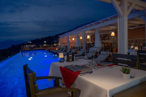 a restaurant with a table and a pool at night at Vista Del Amor Faralya in Fethiye