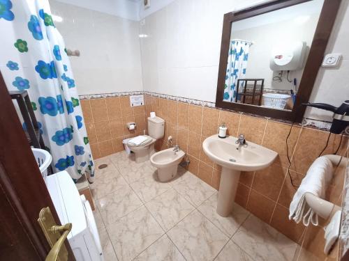 bagno con lavandino, servizi igienici e specchio di VV Mirador Isla Bonita "by henrypole home" a Mazo