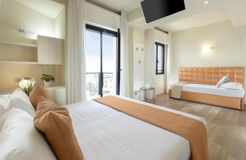 una camera con due letti e una grande finestra di Hotel 2000 con Piscina e Giardino a Riccione