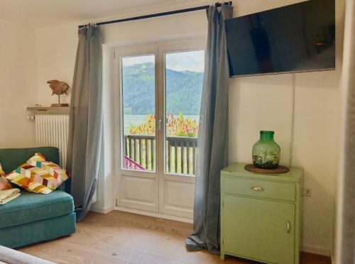 ein Wohnzimmer mit einer Glasschiebetür und einem Fenster in der Unterkunft Ferienwohnung Strandbad - Alpen PopArt am See in Schliersee