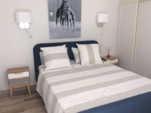 une chambre avec un grand lit avec des oreillers blancs dans l'établissement Studio climatisé avec petit jardin, à Villeneuve-lès-Avignon