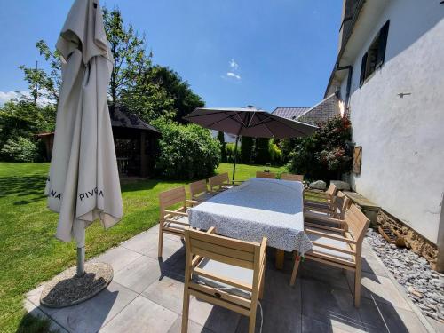 a table and chairs and an umbrella on a patio at Baroque villa near Bled - Resort Vidmar in Lesce