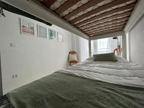 Un dormitorio con una cama y una ventana grande. en El apartamento de Lola, en Mogro