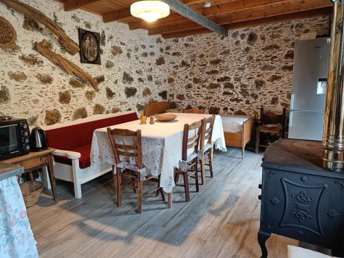 a dining room with a table with chairs and a refrigerator at Casa Pappadiana Traditional stonehouse in Kefálion