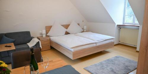 a bedroom with a bed and a chair and a table at Ferienappartements inTOuR in Ockfen