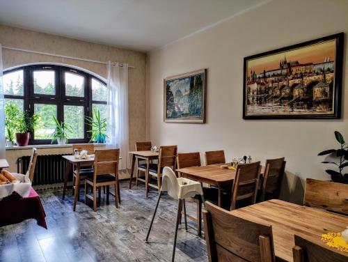 a restaurant with wooden tables and chairs and a window at GRAND HARRACHOV PENSION v centru in Harrachov