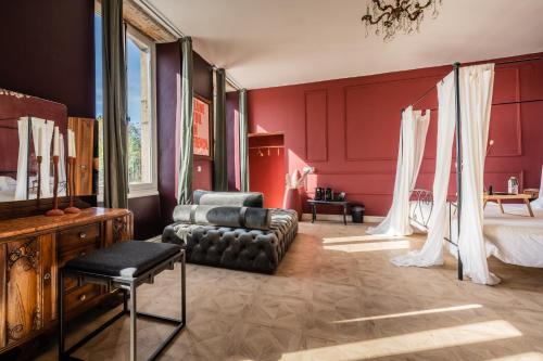 1 dormitorio con paredes rojas, 1 cama y 1 sofá en Chateau Melay, en Melay