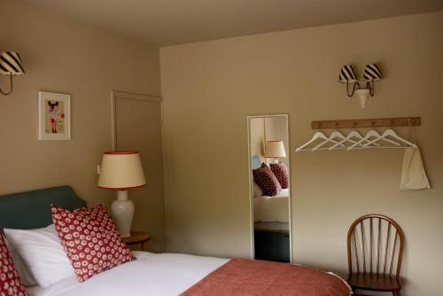 a hotel room with a bed and a mirror at The Queen's Head in Broad Chalke