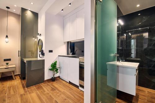 una cucina con armadi bianchi e parete verde di Amuse Luxury Apartments a Città di Zante