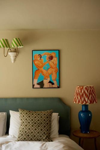 a bedroom with a bed and a painting on the wall at The Queen's Head in Broad Chalke