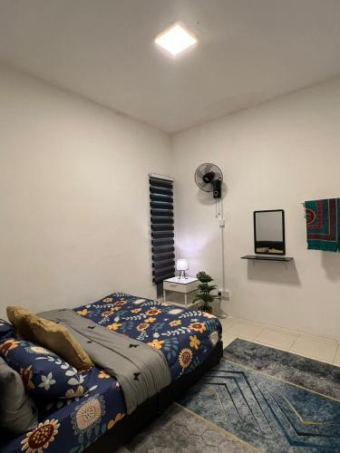 1 dormitorio con 1 cama y ventilador en Ayu Homestay en Tanah Rata