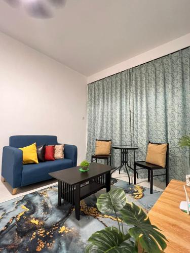 sala de estar con sofá azul y mesa en Ayu Homestay en Tanah Rata