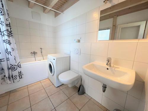 uma casa de banho branca com um WC e um lavatório em Strandpark Sierksdorf H094 em Sierksdorf