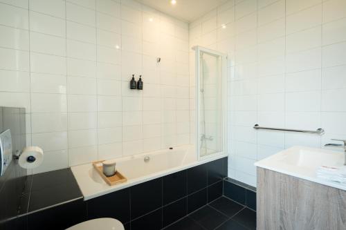 a bathroom with a tub and a sink at Chateau Melay in Melay