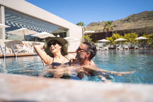 Ein Mann und eine Frau im Schwimmbad. in der Unterkunft Iberostar Heritage Grand Mencey in Santa Cruz de Tenerife