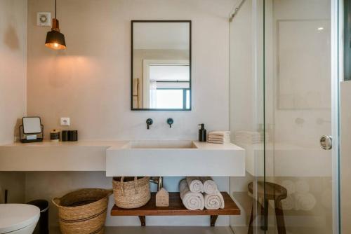 a white bathroom with a sink and a mirror at Casa da Ursa in Colares